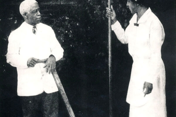 Isaac and Mary Scott holding garden tools in a garden