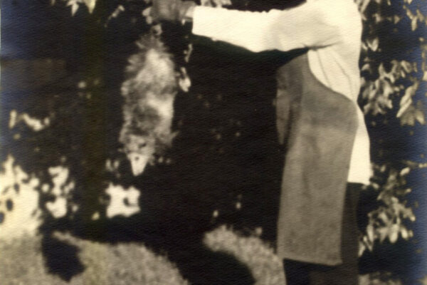 Isaac Scott in garden with possum